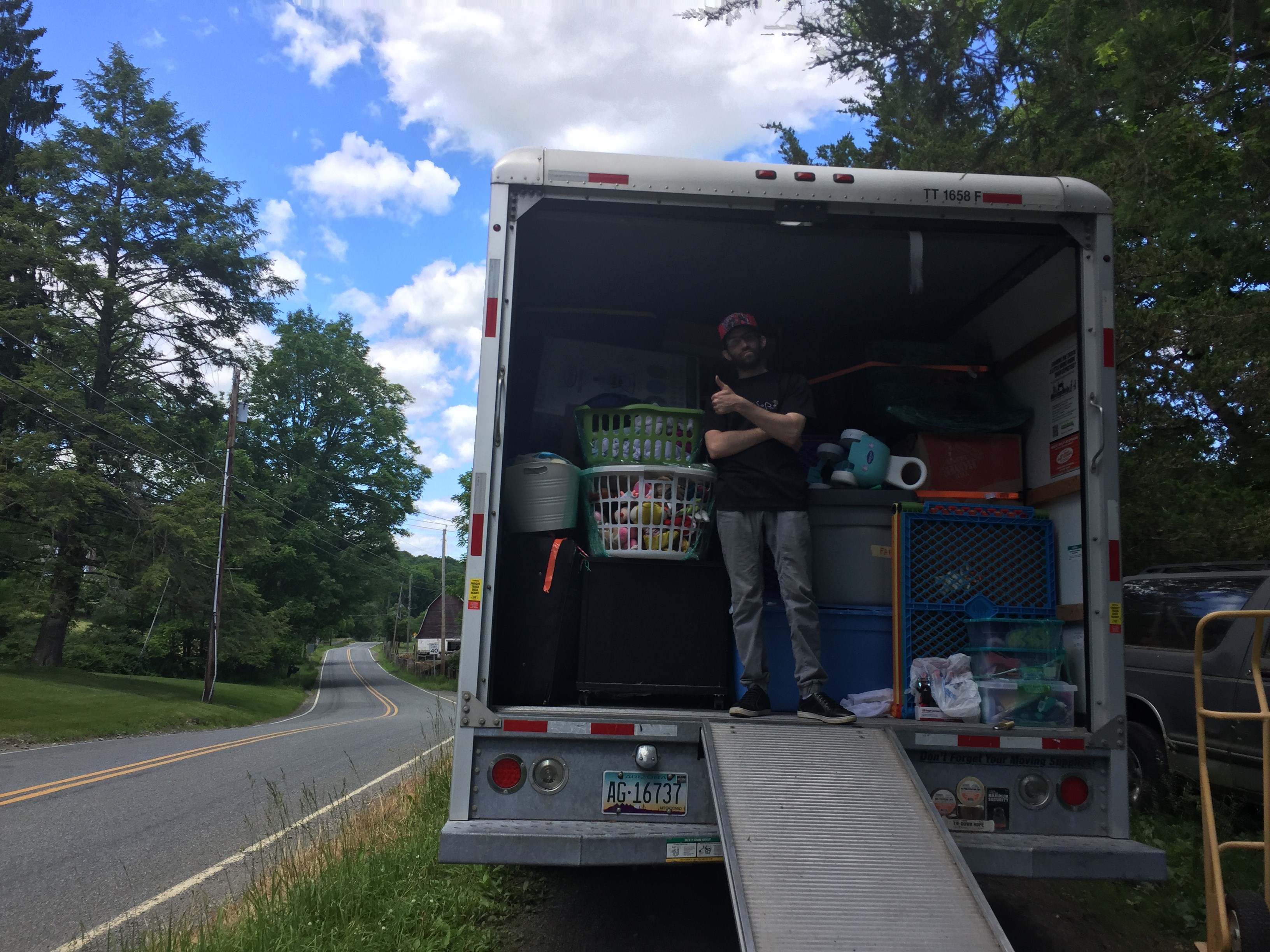 Two professional movers carrying a couch from a moving truck