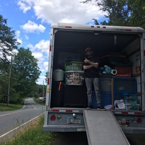Mover securing furniture with straps inside a rental truck
