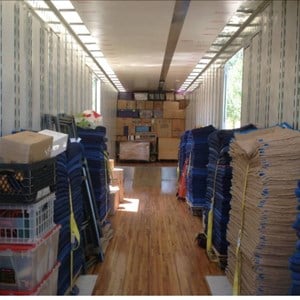 Team lifting a heavy dresser into a moving van